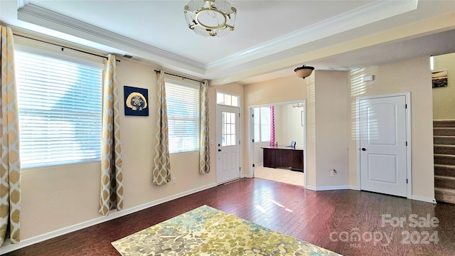 foyer with visible vents, ornamental molding, wood finished floors, baseboards, and stairs