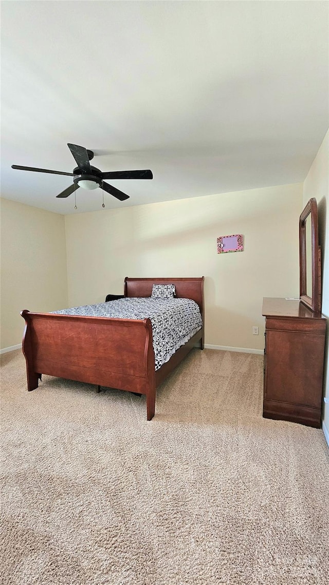 carpeted bedroom with baseboards and a ceiling fan