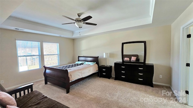 bedroom with light carpet, visible vents, a tray ceiling, and ornamental molding