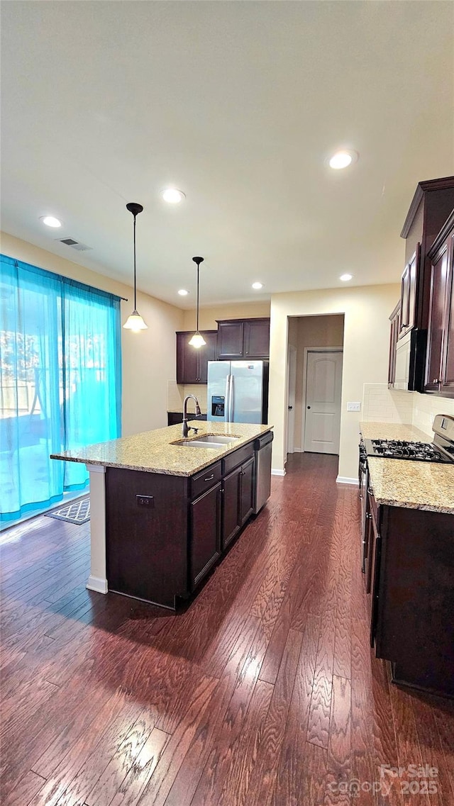 kitchen with dark wood-type flooring, visible vents, dark brown cabinets, and appliances with stainless steel finishes