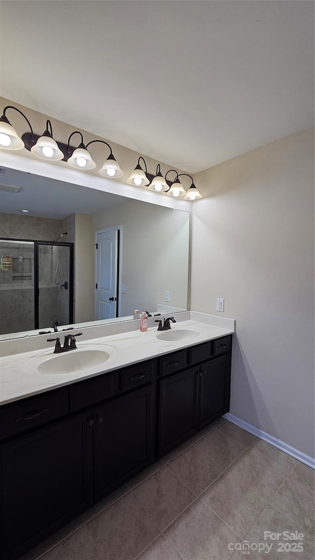 full bathroom with tile patterned floors, double vanity, a sink, and a stall shower