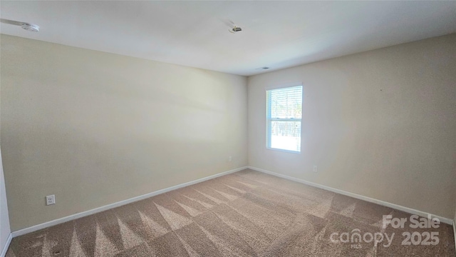 unfurnished room featuring baseboards and carpet flooring
