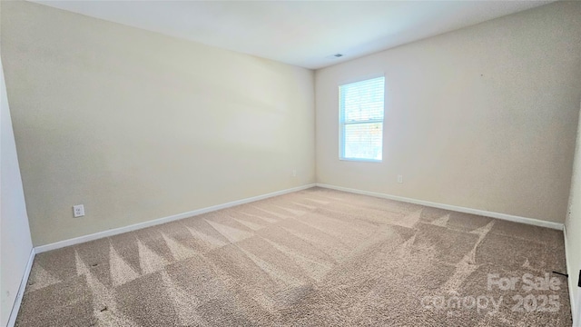 empty room featuring visible vents, baseboards, and carpet