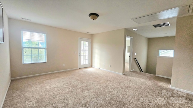 spare room featuring carpet flooring, visible vents, and baseboards