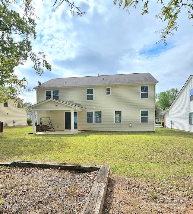 rear view of property featuring a patio and a lawn
