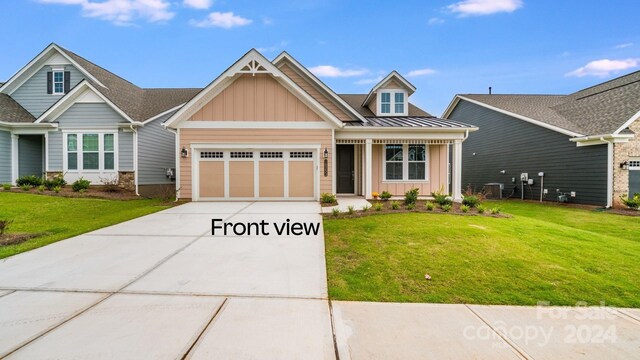 craftsman house with a front yard and a garage