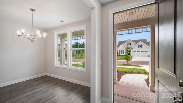 foyer with dark hardwood / wood-style flooring, an inviting chandelier, and a wealth of natural light