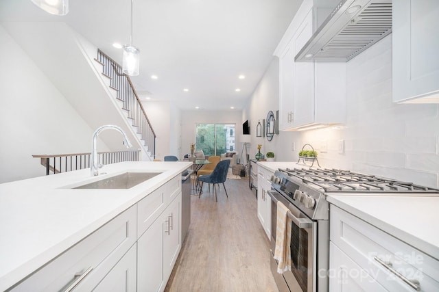 kitchen featuring backsplash, custom range hood, light wood-type flooring, appliances with stainless steel finishes, and white cabinetry