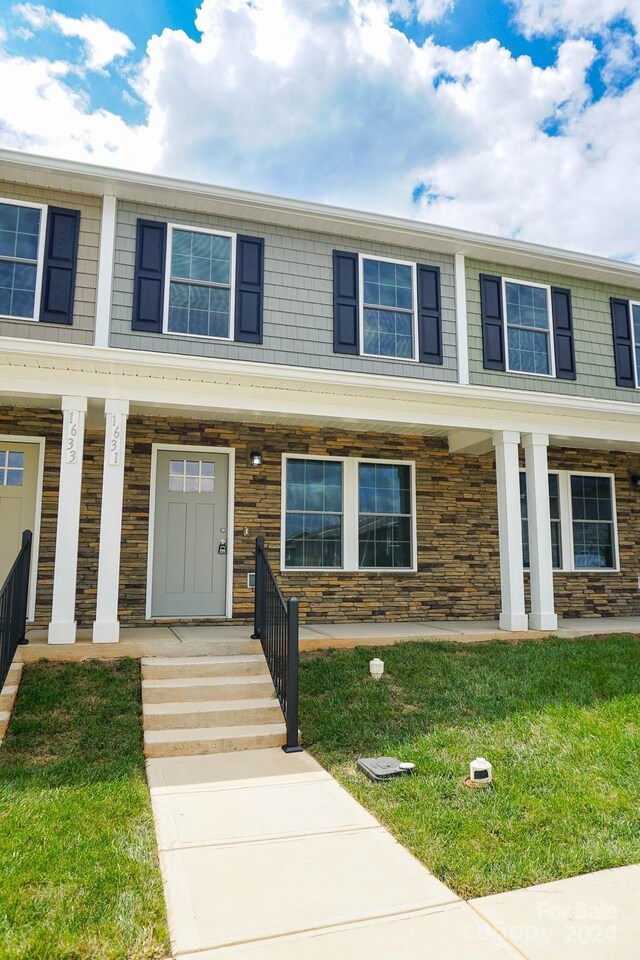 multi unit property featuring a porch and a front lawn