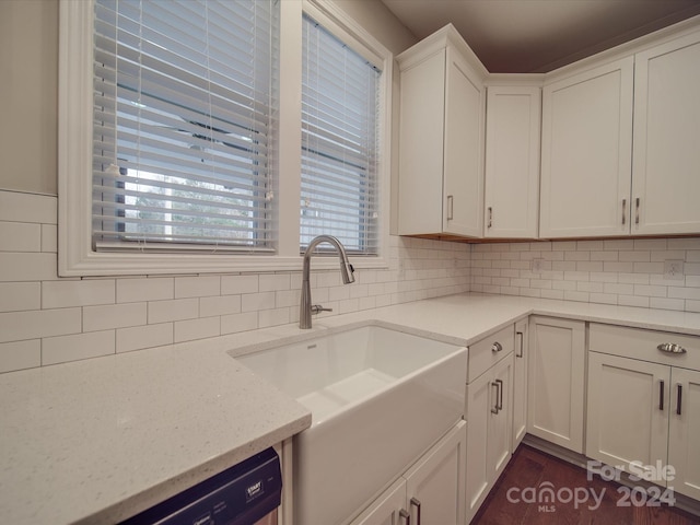 kitchen with white cabinets, dishwashing machine, sink, and backsplash