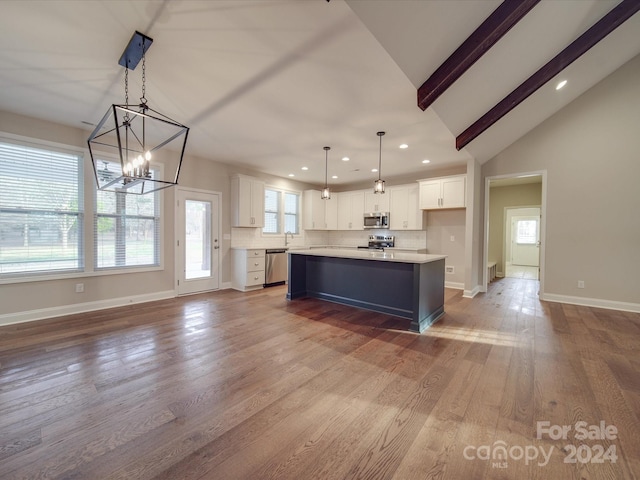 kitchen with appliances with stainless steel finishes, hardwood / wood-style floors, and decorative light fixtures