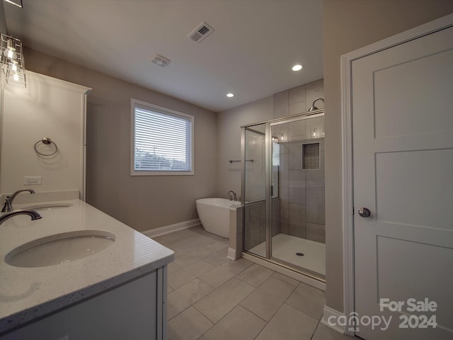 bathroom with dual vanity, plus walk in shower, and tile patterned flooring