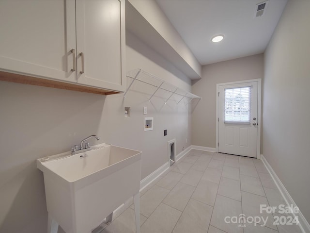 laundry area featuring light tile patterned floors, cabinets, electric dryer hookup, sink, and washer hookup