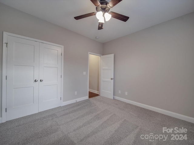 unfurnished bedroom featuring carpet flooring, a closet, and ceiling fan