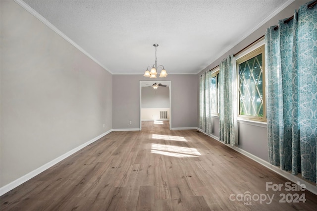 interior space with a textured ceiling, crown molding, and wood-type flooring