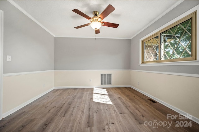 empty room featuring ceiling fan, ornamental molding, and hardwood / wood-style flooring