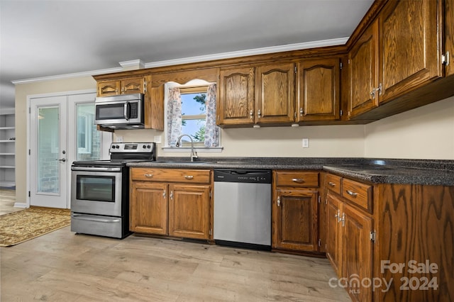 kitchen featuring dishwasher, light hardwood / wood-style floors, sink, crown molding, and stove