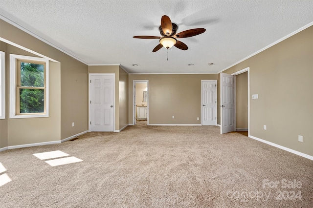 unfurnished room with a textured ceiling, ceiling fan, ornamental molding, and light colored carpet