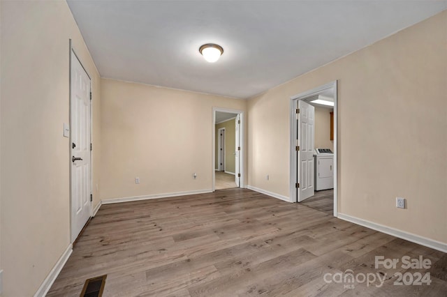 spare room featuring washer / clothes dryer and hardwood / wood-style floors