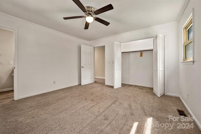 unfurnished bedroom featuring ceiling fan, carpet flooring, crown molding, and a closet