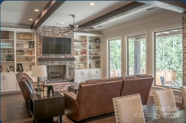 living room with ceiling fan, beam ceiling, dark wood-type flooring, a brick fireplace, and built in features