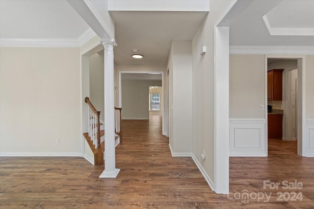 hall with ornate columns, ornamental molding, and dark hardwood / wood-style floors