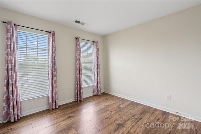 unfurnished room with hardwood / wood-style floors