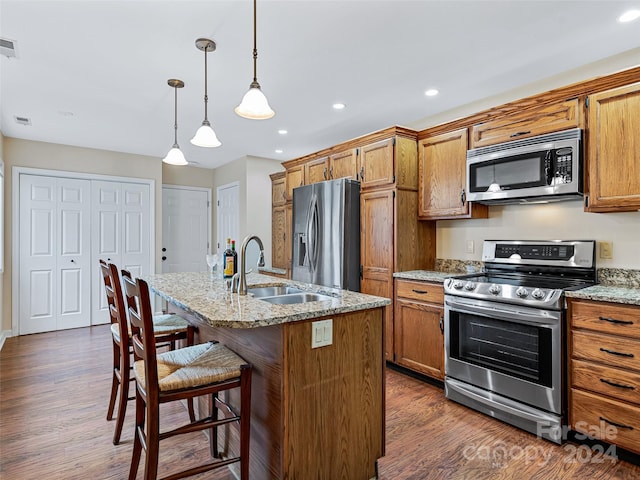 kitchen featuring stainless steel appliances, a sink, and brown cabinets