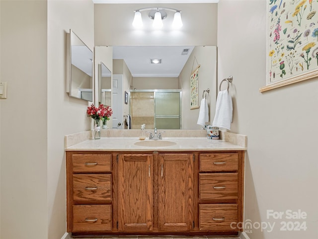 bathroom featuring a stall shower, baseboards, visible vents, and vanity