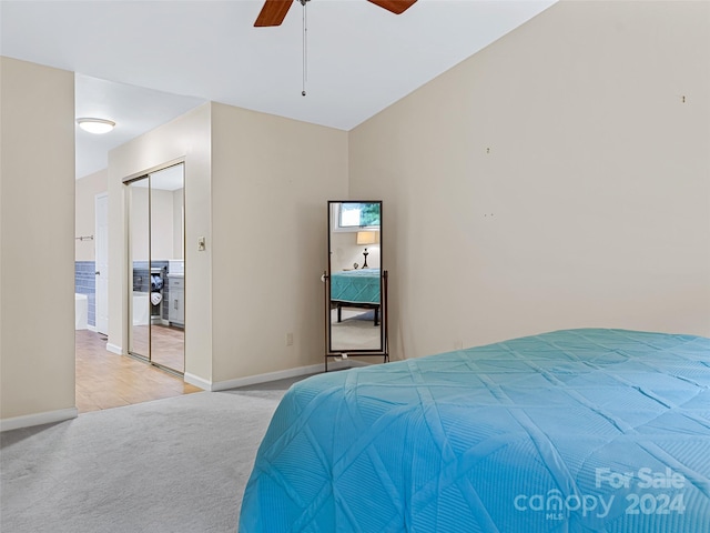 bedroom featuring a ceiling fan, a closet, light carpet, and baseboards