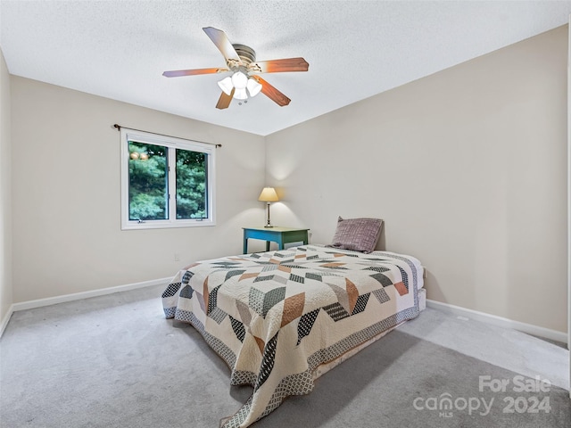 bedroom with carpet, a textured ceiling, and baseboards