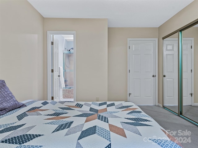 carpeted bedroom with a closet and ensuite bathroom