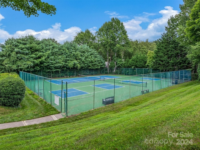 view of sport court with a lawn and fence