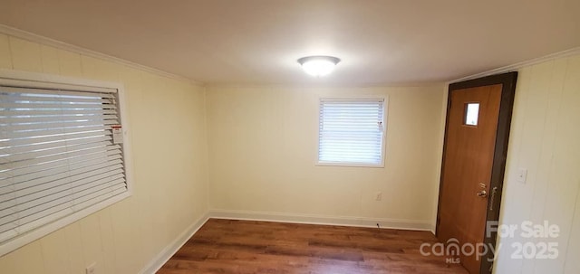 empty room featuring crown molding and dark wood-type flooring