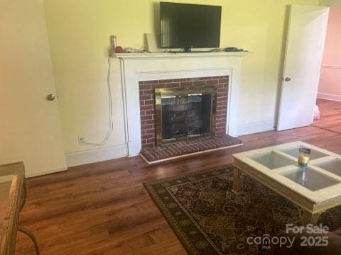 living room with dark wood-type flooring and a fireplace