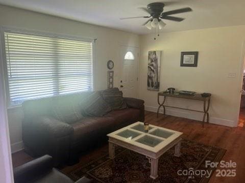 living room with dark wood-type flooring and ceiling fan