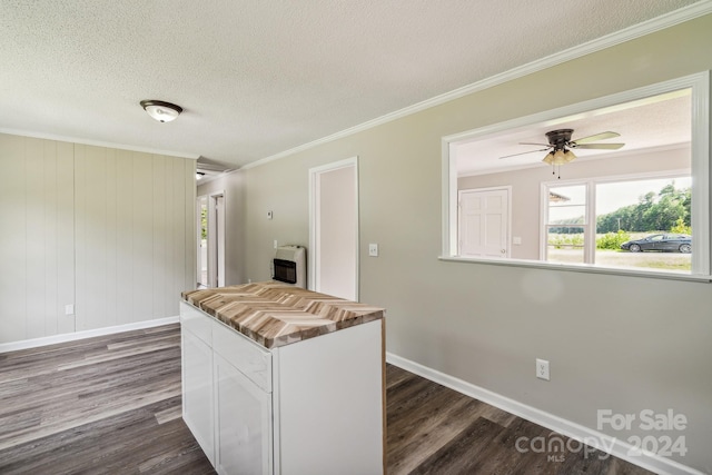 kitchen with white cabinetry, ornamental molding, and dark hardwood / wood-style flooring