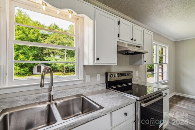 kitchen featuring hardwood / wood-style floors, white cabinetry, sink, stainless steel range with electric stovetop, and a textured ceiling