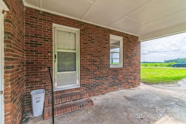 view of exterior entry with a patio