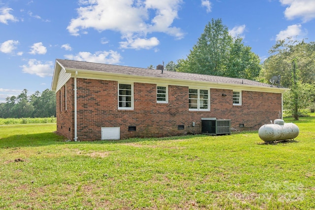 back of house featuring central AC unit and a lawn