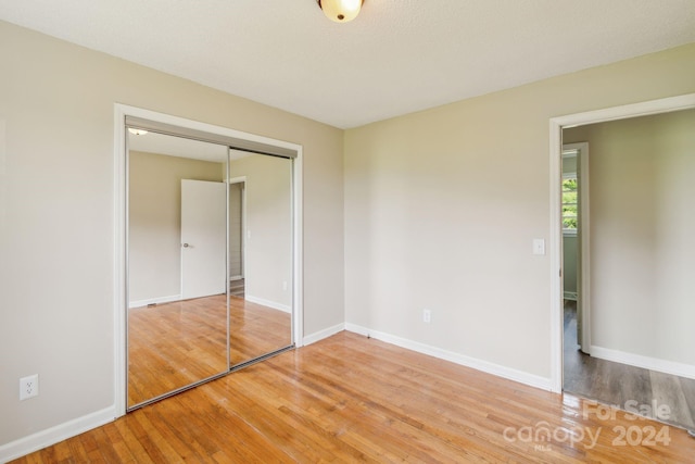 unfurnished bedroom featuring hardwood / wood-style flooring and a closet