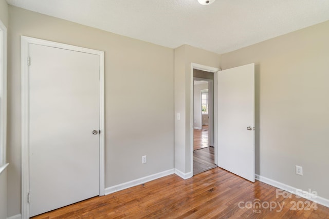 unfurnished bedroom with hardwood / wood-style floors