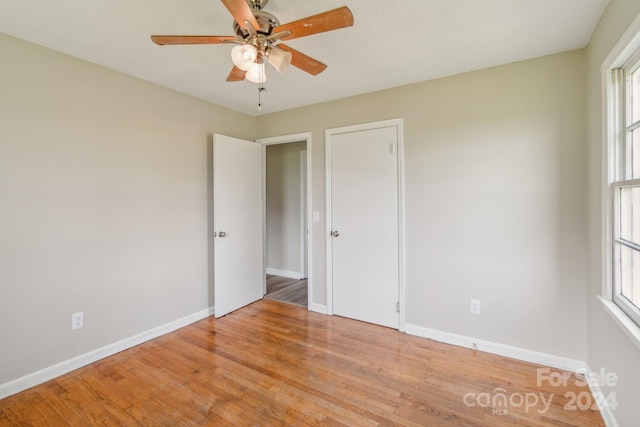 unfurnished bedroom with ceiling fan and light wood-type flooring