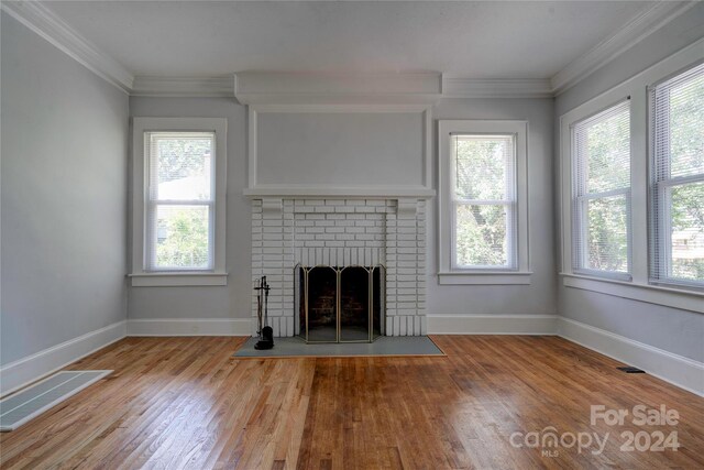 unfurnished living room featuring a fireplace, light hardwood / wood-style flooring, and crown molding