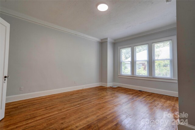 spare room with crown molding and hardwood / wood-style floors