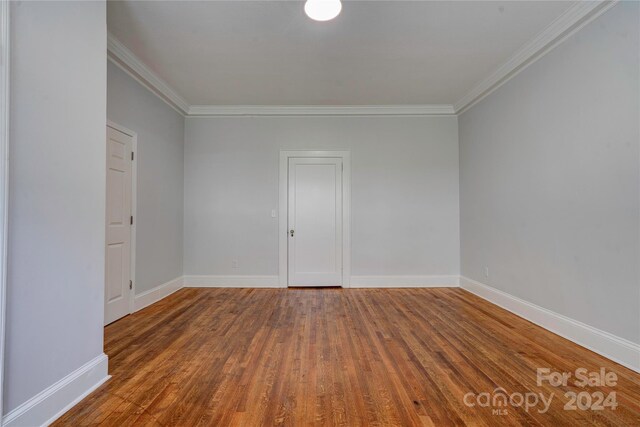 unfurnished room with hardwood / wood-style floors and crown molding