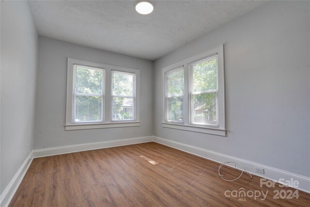 unfurnished room with hardwood / wood-style flooring