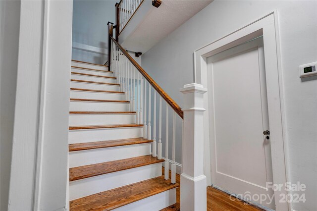 staircase with wood-type flooring