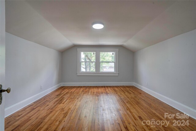 bonus room with light hardwood / wood-style floors and vaulted ceiling