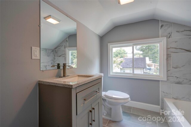 bathroom with toilet, vanity, tile patterned flooring, and lofted ceiling